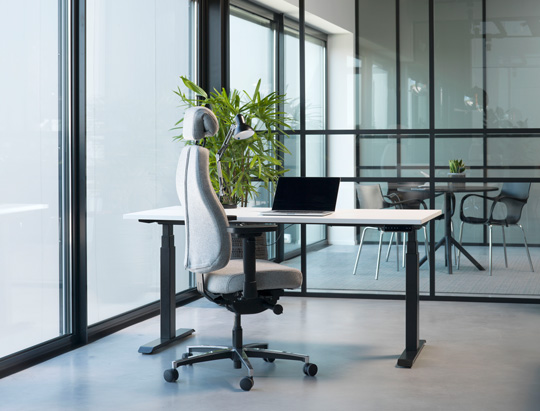 Ein modernen Büro mit einem ergonomischgeformten grauen Bürostuhl 
